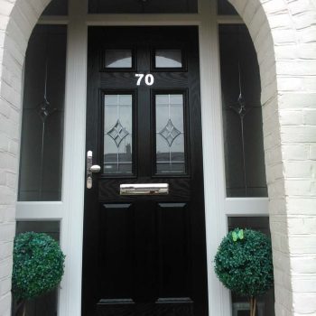 Black composite door with glazed square panels and decorative glass